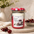 A jar candle labeled 'Sweet Cherry' by Maren+Lilla Candle, styled on a stone tray with red cherries and a neutral background.